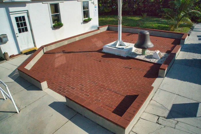The brick patio, with the flagpole and the U.S. Lighthouse Service bell